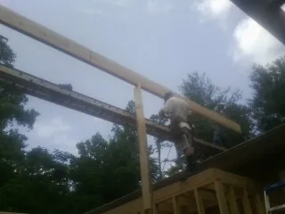 Carpenter setting a ridge beam over a new addition frame — Ice Dam Removal by Roofing Brothers in Clackamas