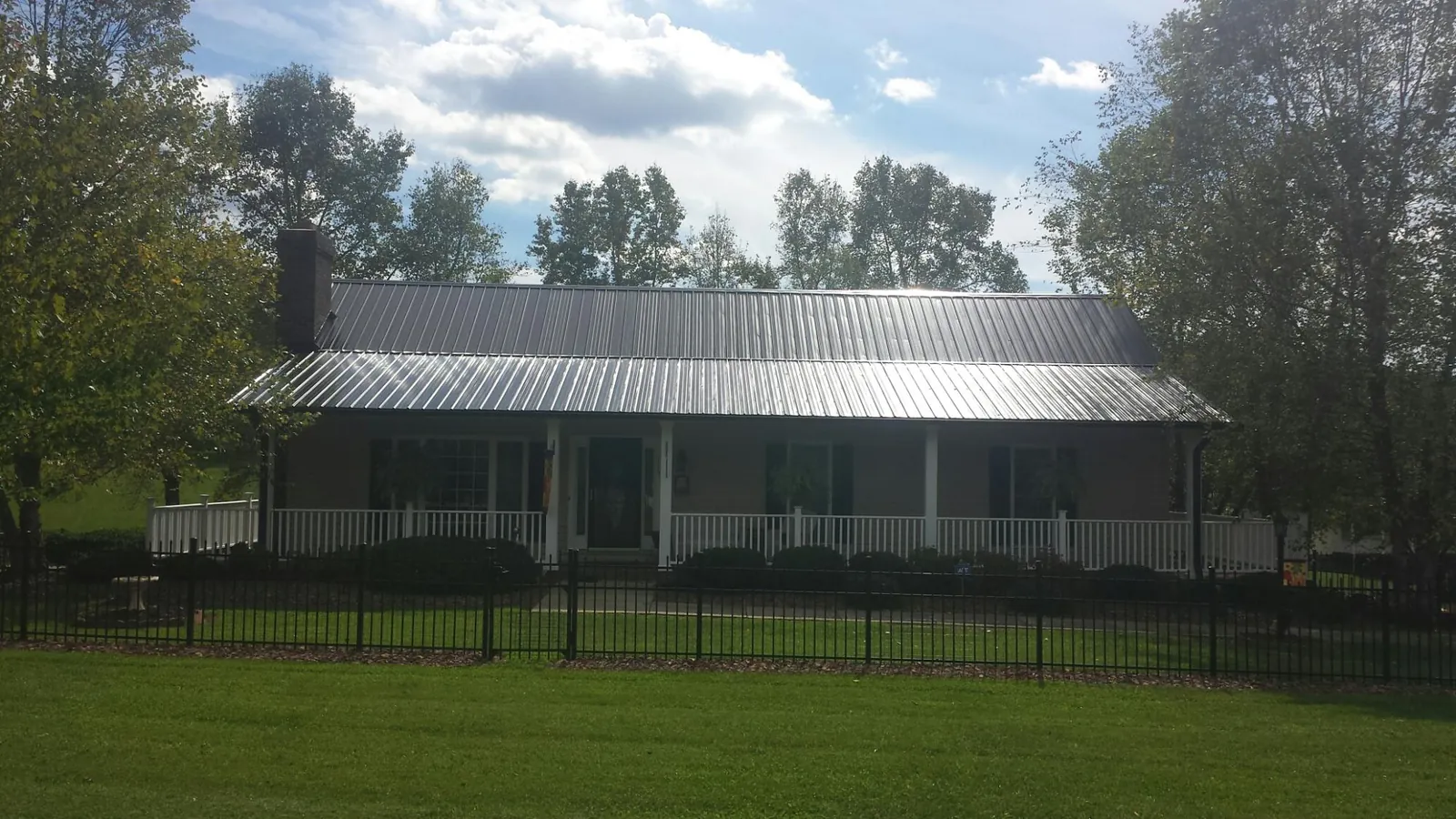 Gray metal roof on a brick ranch with a full width front porch — Gutter Guard Installation work by our crew in Clackamas